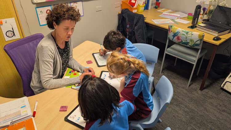 3 students working with an intervention teacher.