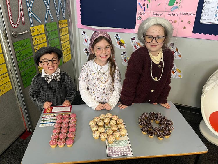 3 kinder students celebrating their 100 days of learning.