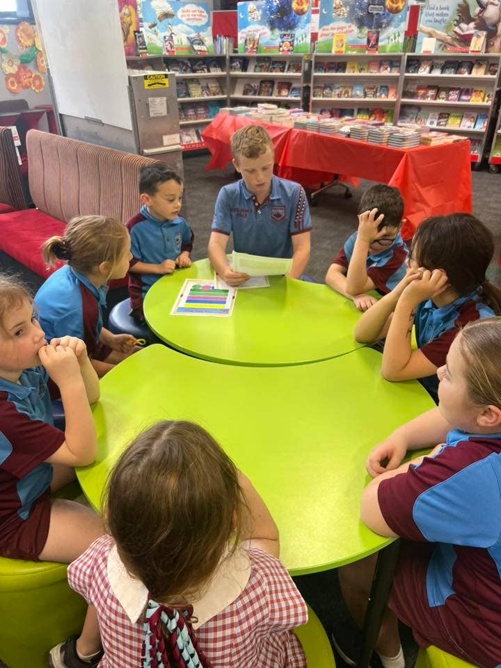 Younger students listening to a Year 6 student.