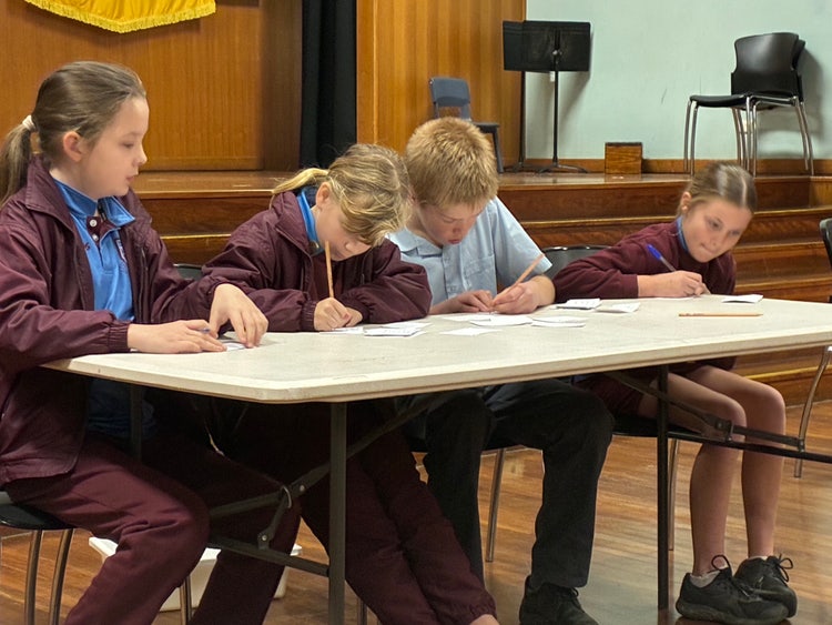 Four students in a debate writing notes.