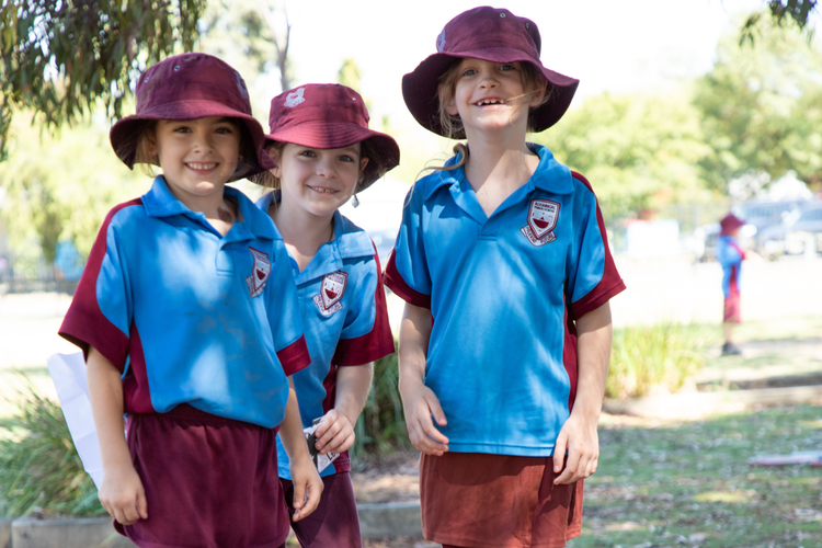 3 girls under a tree, smiling.